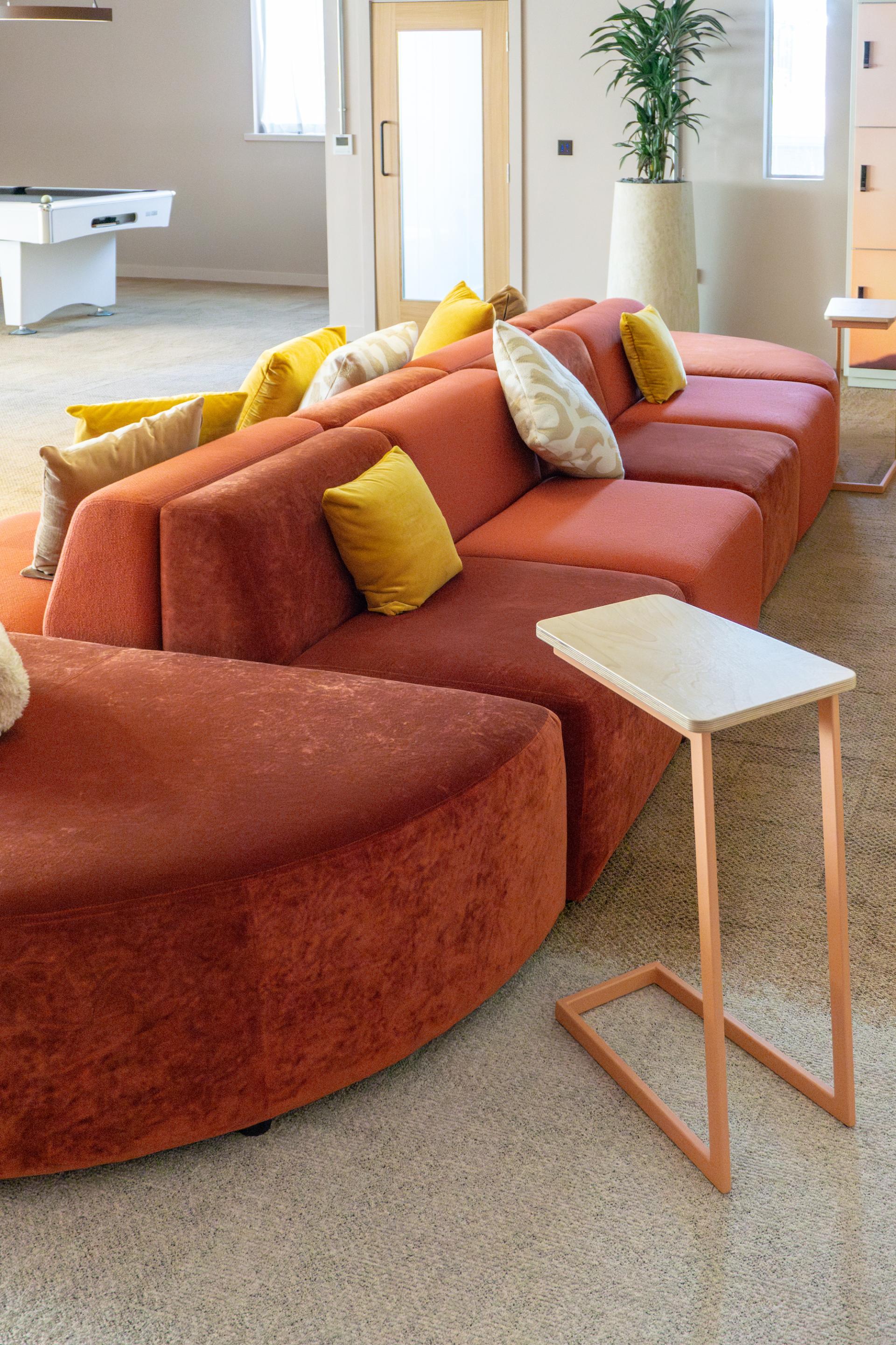 Stylish orange and yellow seating in a modern collaborative space at Crown Paints' Liz Hickson Academy.