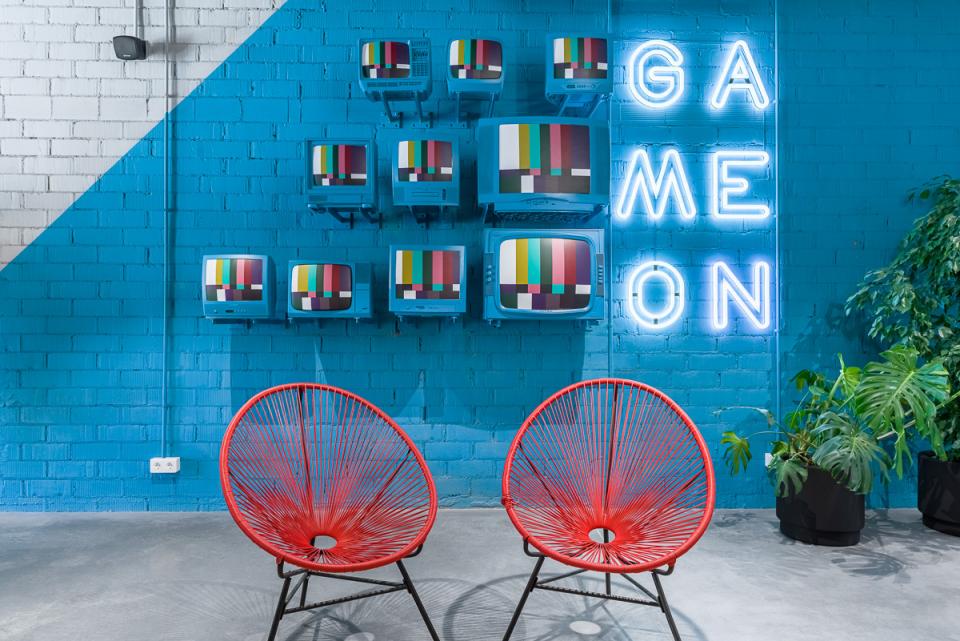 Brightly colored retro TVs and neon lights create a vibrant co-working space at The Student Hotel in Barcelona.