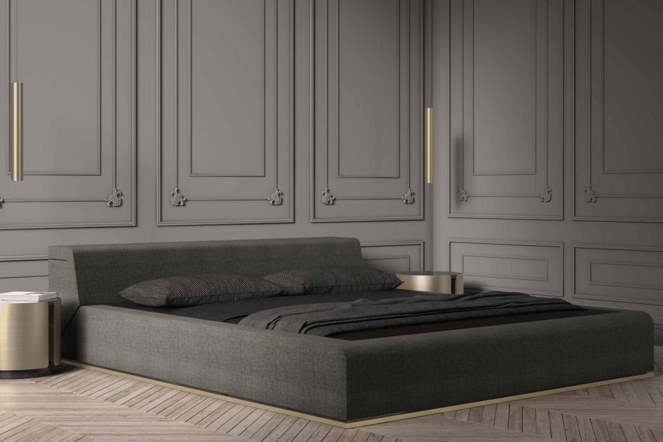 Elegant minimalist bed by Nabil Issa, featuring sleek lines, dark fabric, and distinct gold accents in a modern interior.