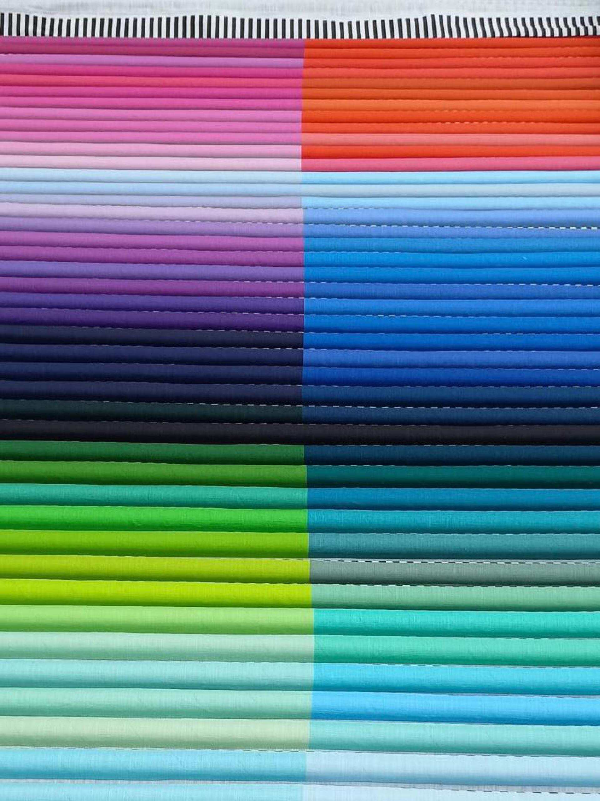 Vibrant layers of fabric in diverse colors, showcasing Margo Selby's textile artistry for the National Festival of Making.