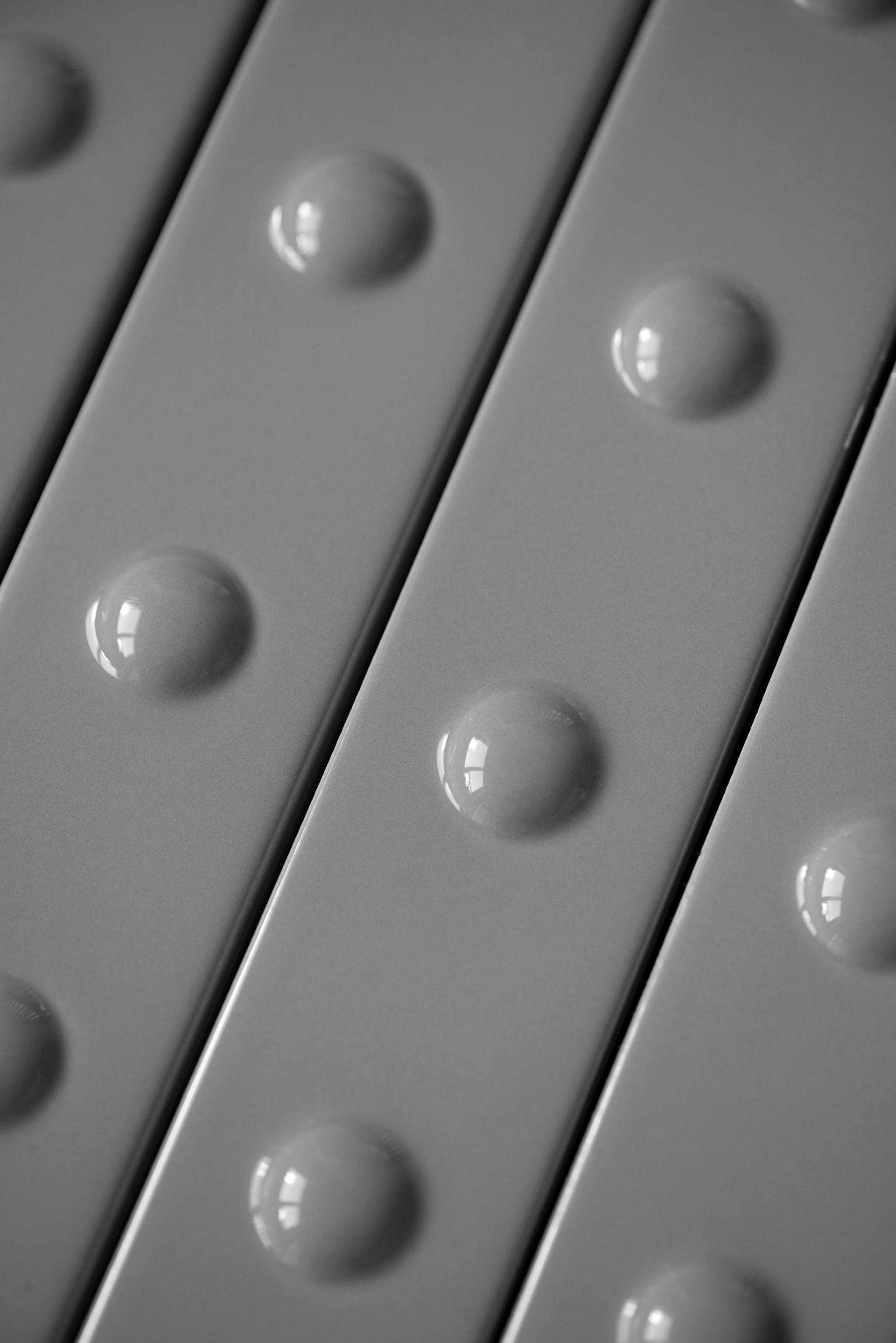 Close-up of textured ceramic tiles featuring raised circular dots, showcasing Mutina and Studio Bouroullec's design collaboration.