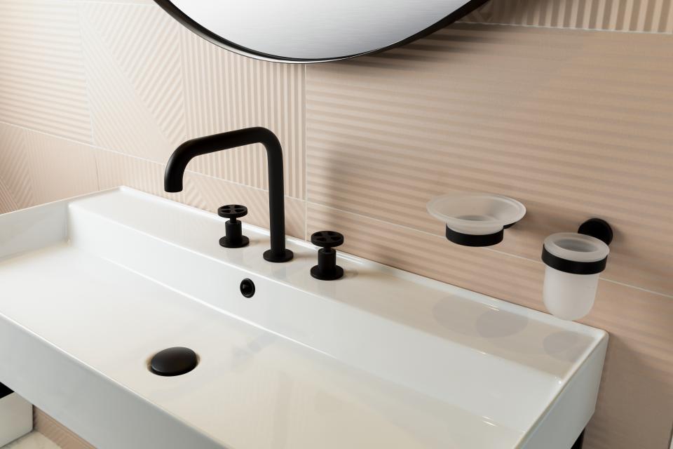 Sleek black faucet and accessories atop a modern white sink, showcasing elegant design for contemporary bathrooms in Dubai.