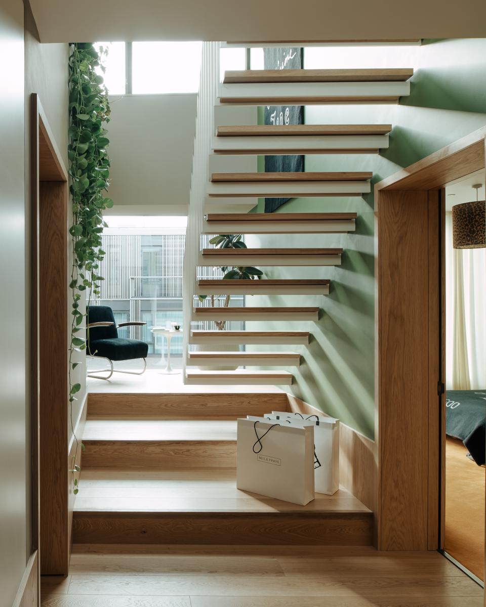 Elegant staircase design showcasing natural light and greenery, featured in Bella Freud and Maria Speake's interiors for Helios 710.