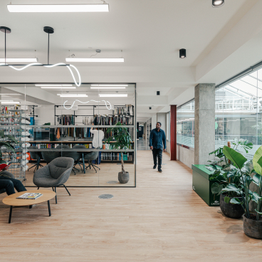 Modern office space for Lacoste featuring a New York warehouse aesthetic, with stylish seating, greenery, and collaborative areas.