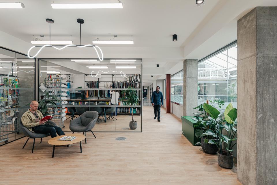Modern office space for Lacoste featuring a New York warehouse aesthetic, with stylish seating, greenery, and collaborative areas.