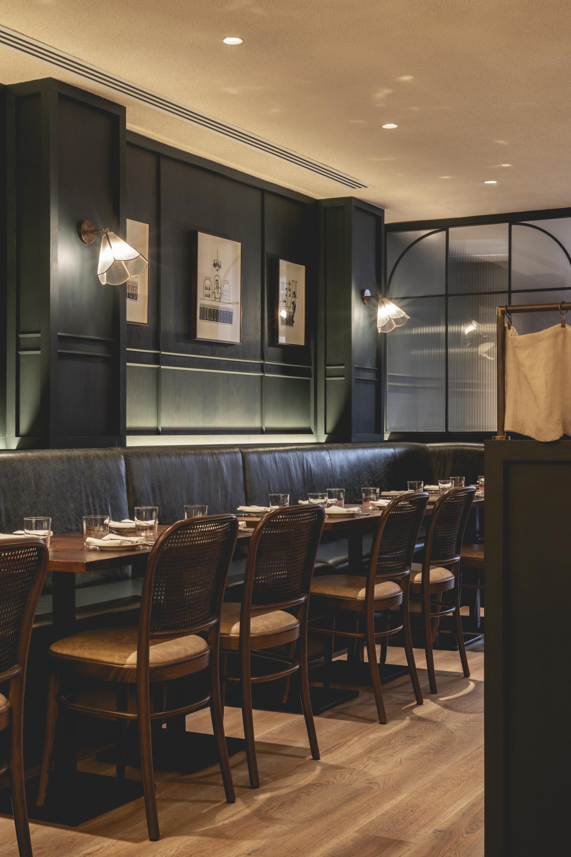 Elegant interior of Studio Found's Fitzrovia restaurant, featuring rustic wooden tables, plush seating, and stylish lighting.