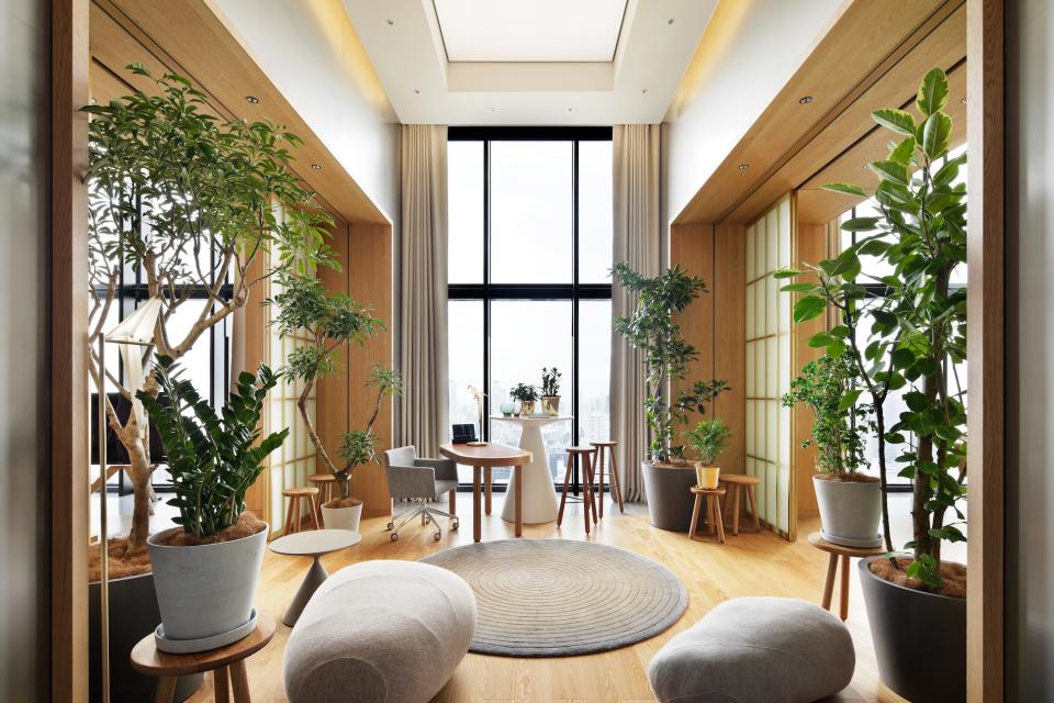 Stylish interior of W Osaka showcasing lush plants, modern furniture, and large windows, embodying contemporary design.