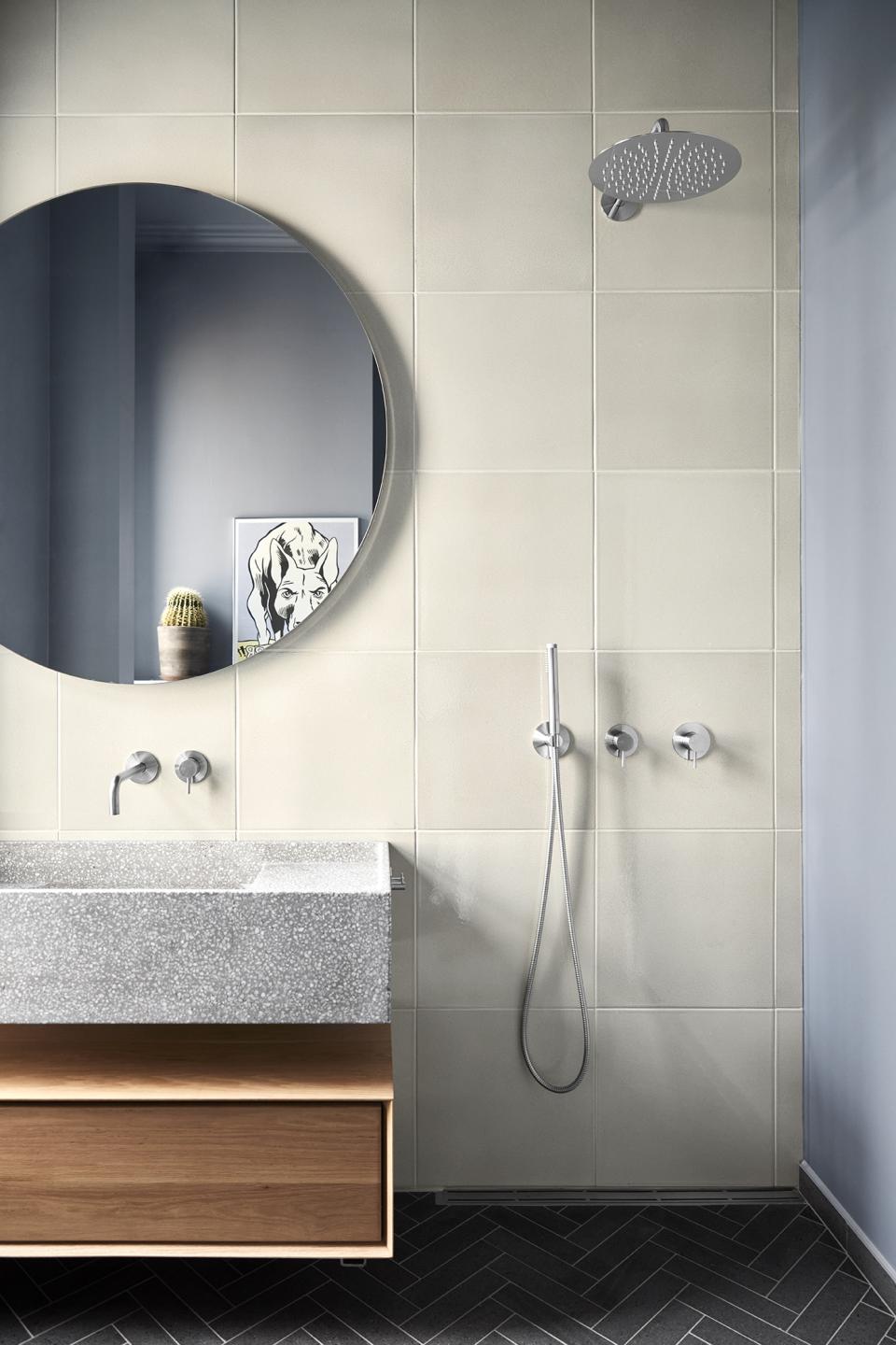 Stylish bathroom design by Emil Thorup featuring d line's Qtoo collection, a round mirror, and textured surfaces.