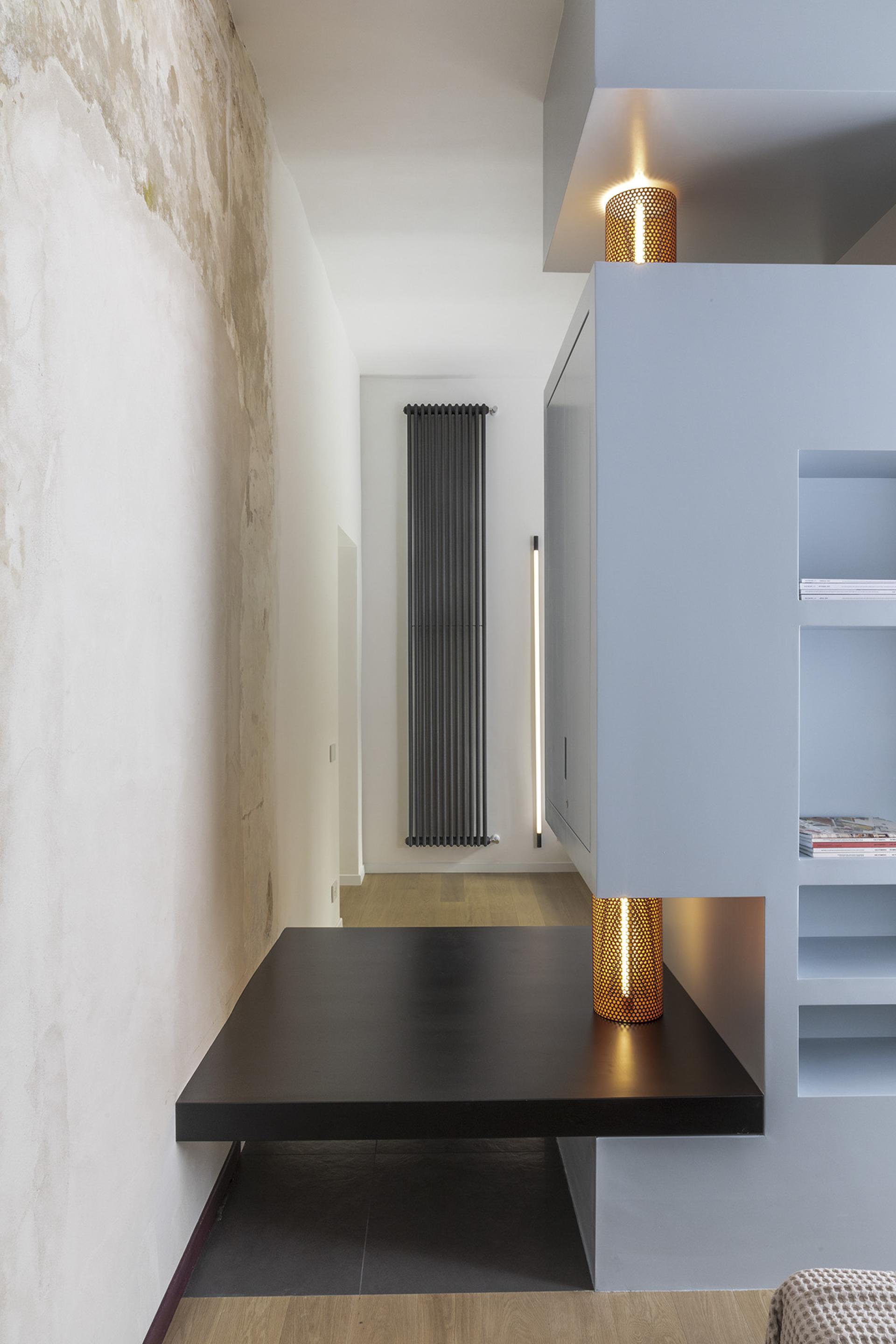 Modern interior design of a compact apartment in Trastevere, featuring sleek furniture, unique lighting, and warm wood elements.