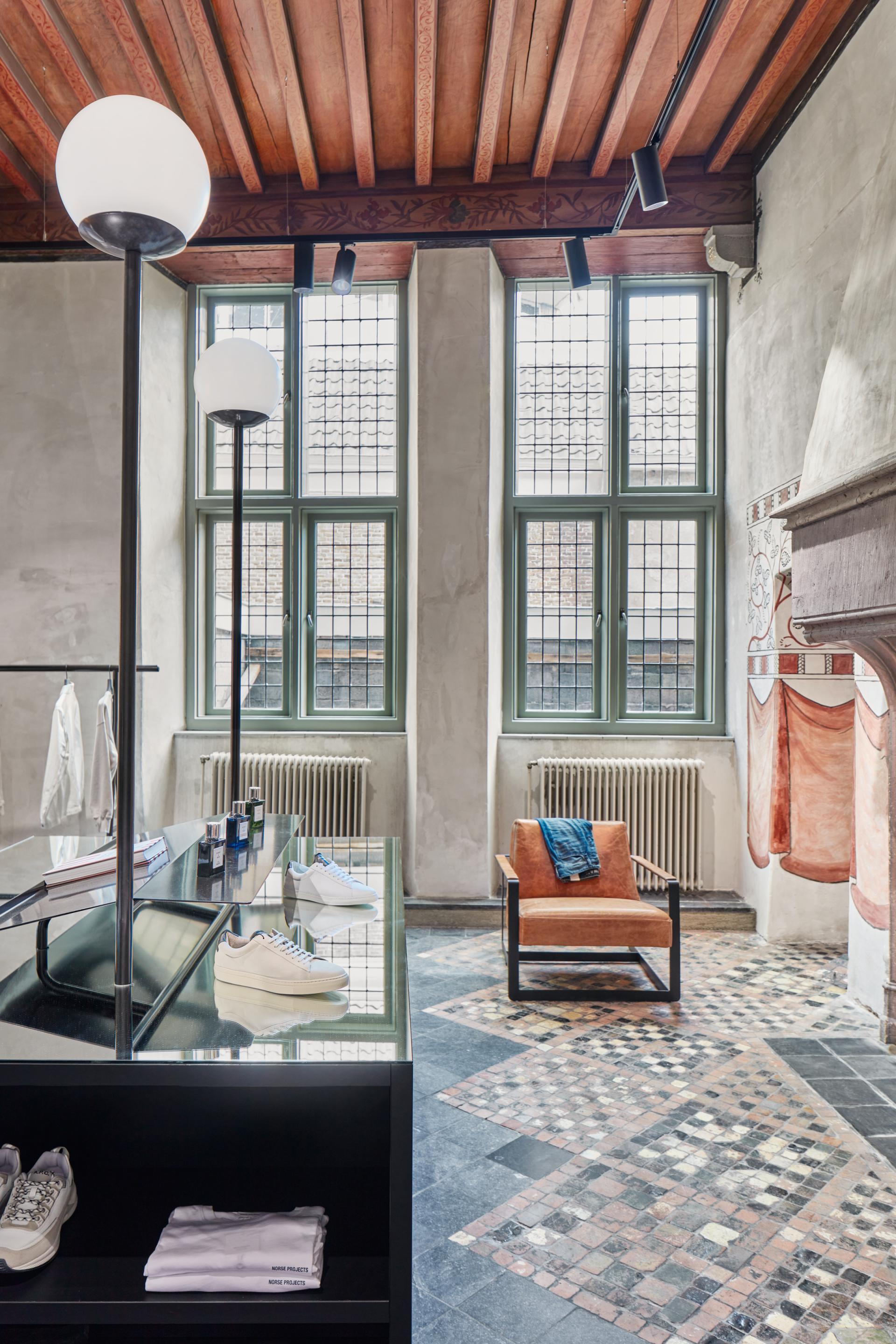 Modern interior of COEF clothing store featuring stylish displays, large windows, and unique flooring in historic Utrecht building.