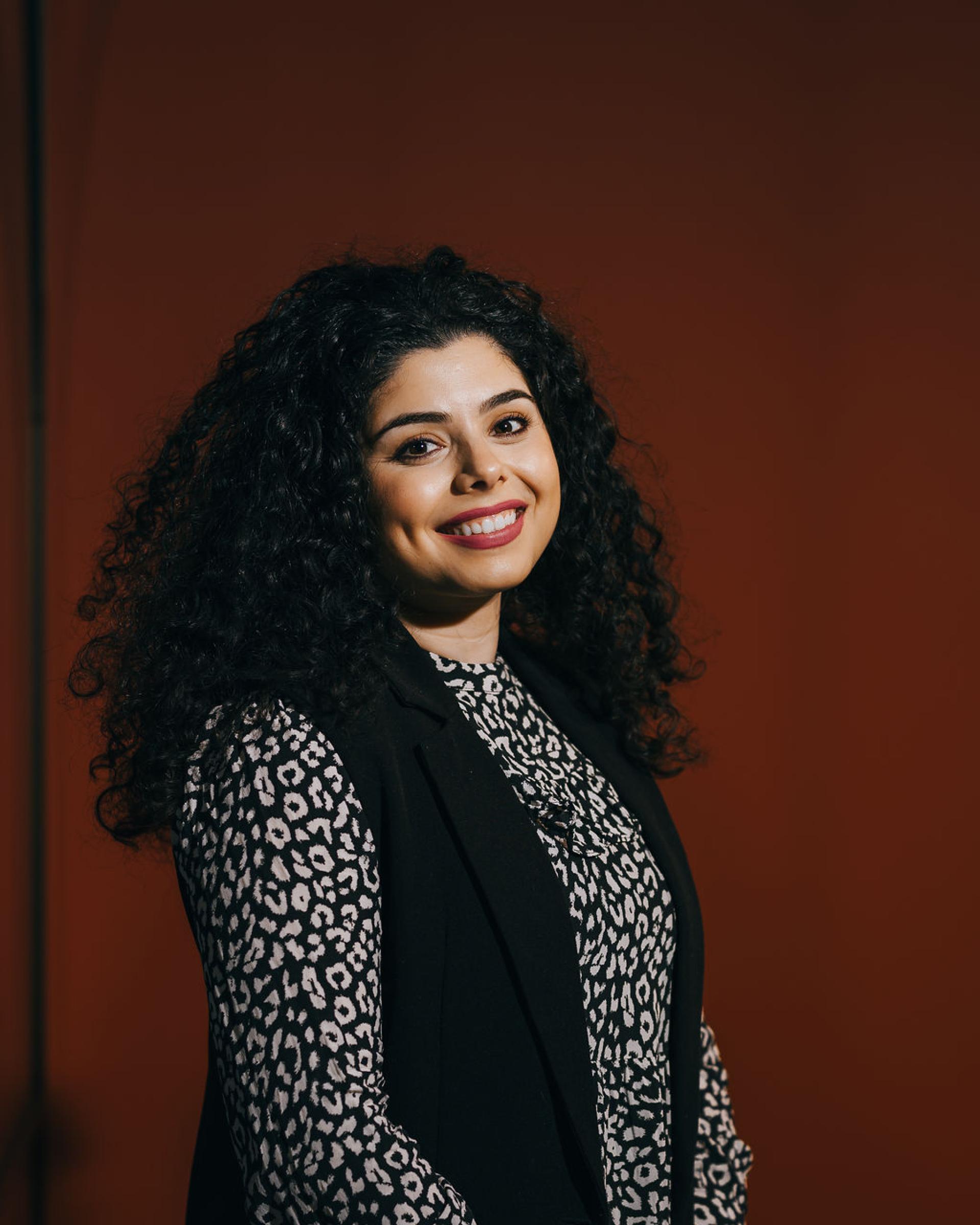 Professional portrait of a woman with curly hair, highlighting themes of innovation and sustainability in biomaterials.