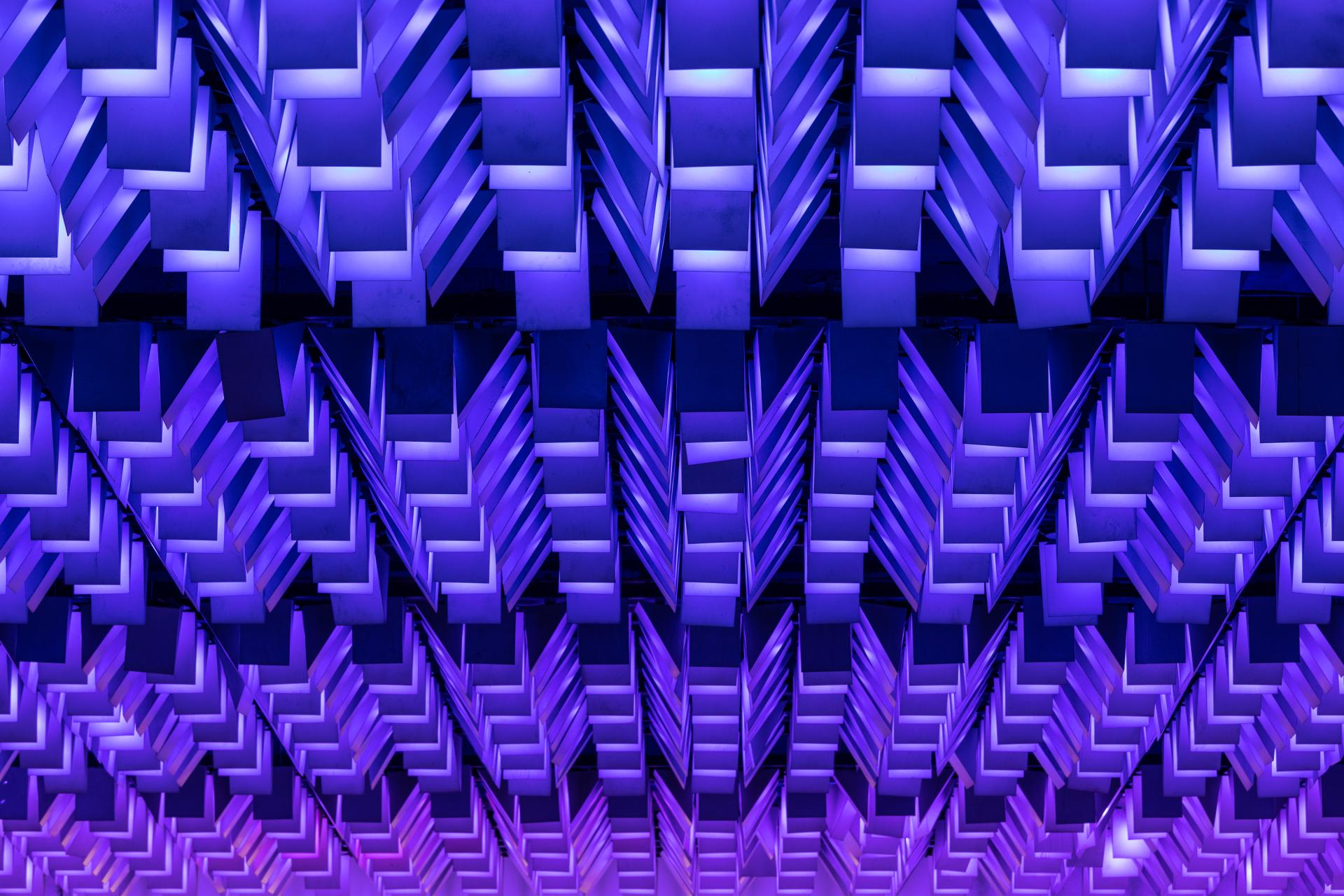 Colorful illuminated ceiling design featuring geometric shapes, enhancing the vibrant ambiance of the New Century community venue.