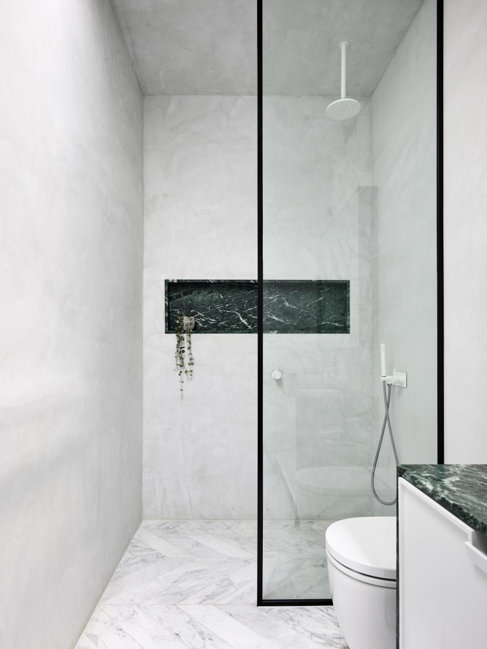 Modern bathroom design featuring minimalist elements, elegant marble details, and a walk-in shower inspired by Parisian aesthetics.