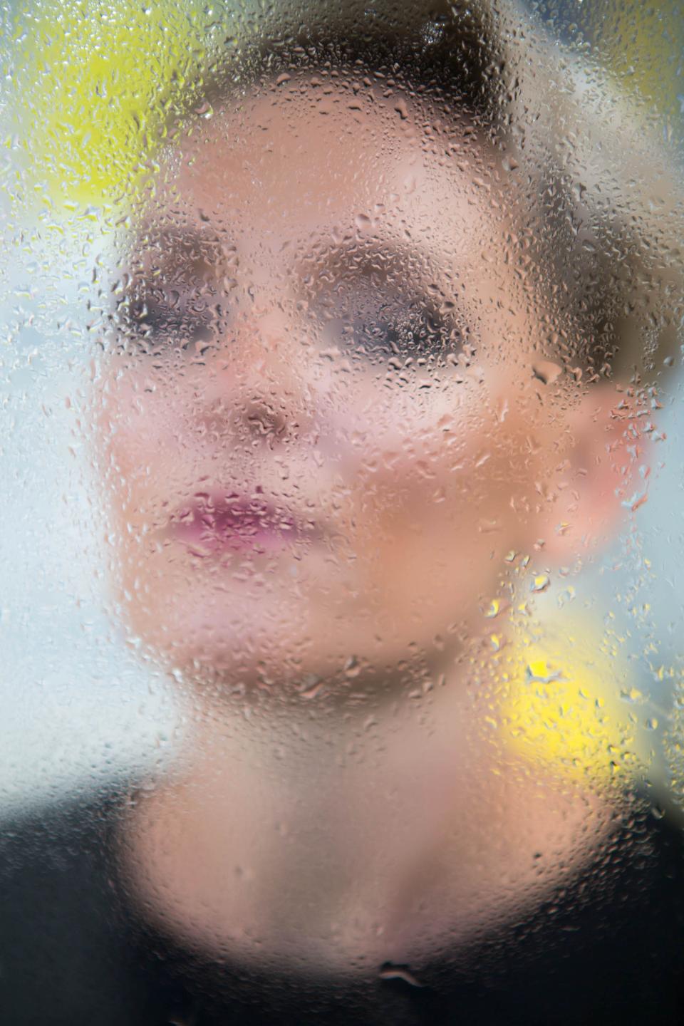 Monika Swindells partially obscured by a fogged glass, embodying themes of design, mindfulness, and connection in her work.