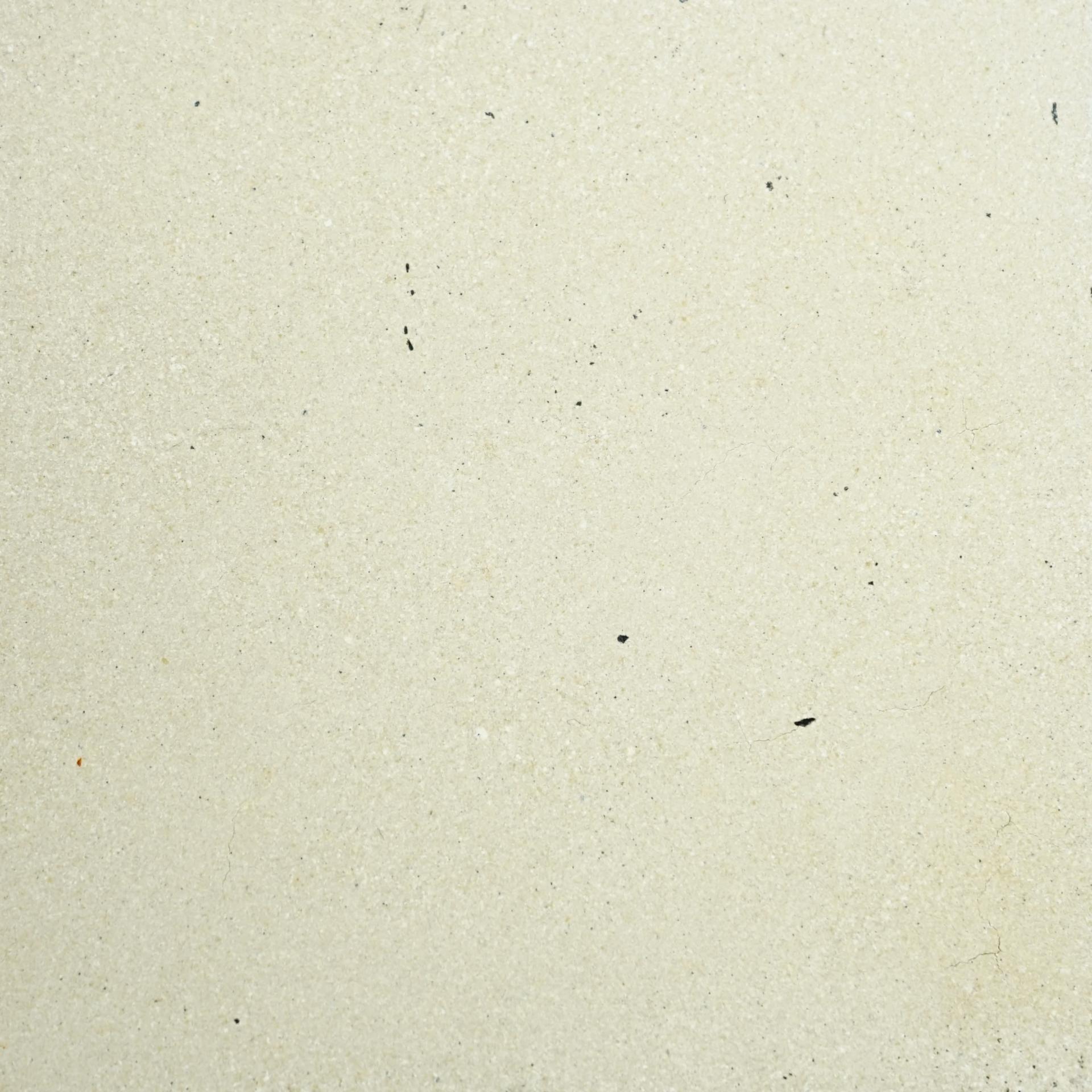 Texture of a light-colored surface featuring small diverse particles, reflecting the creative aspect of DeakinBio’s maker in residence program.