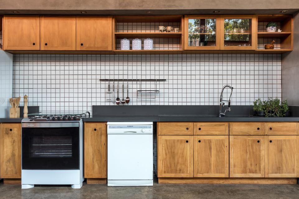 Modern kitchen design featuring wooden cabinetry, sleek countertops, and tile backsplash in The Lake House, Brazil.