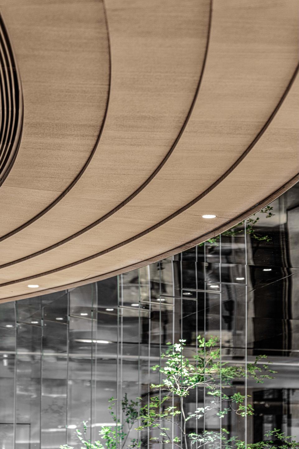 Elegant wood curves and reflective surfaces enhance the otherworldly design of the Foshan Vanke Financial Centre's interior.