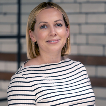 Ellie Philcox, director at Euan Kellie, poses in a stylish striped top, showcasing expertise in planning consultancy.