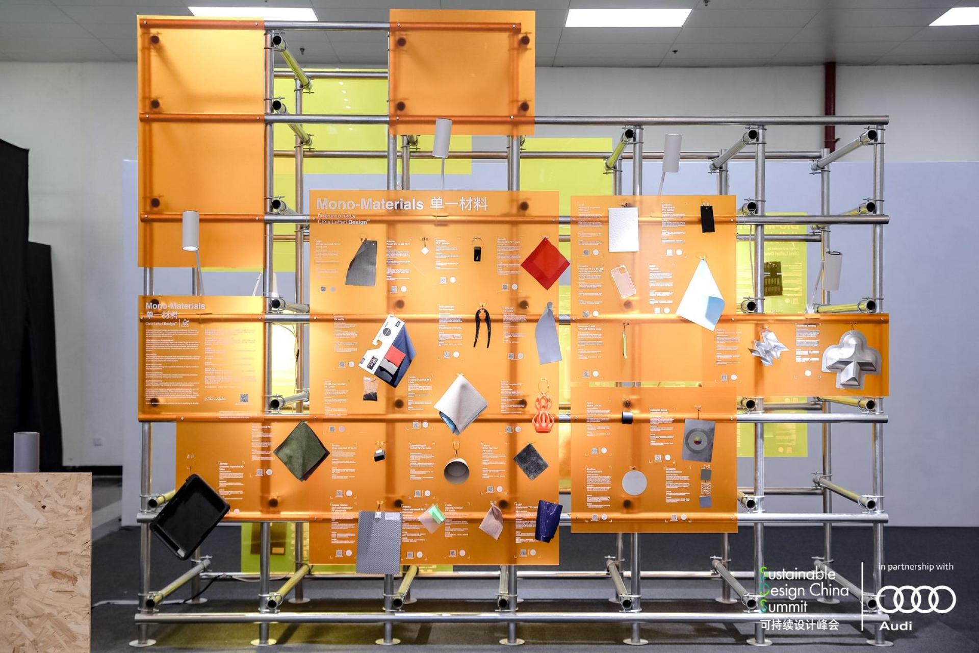 Display of innovative mono-materials used in sustainable design, featuring various samples and information panels at a design summit.