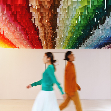 Interactive Color Factory exhibit in New York City featuring colorful ceiling design with visitors exploring the vibrant space.
