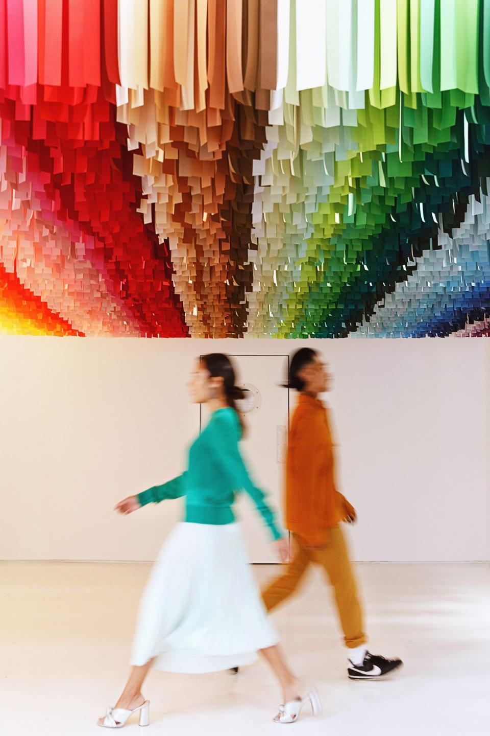 Interactive Color Factory exhibit in New York City featuring colorful ceiling design with visitors exploring the vibrant space.