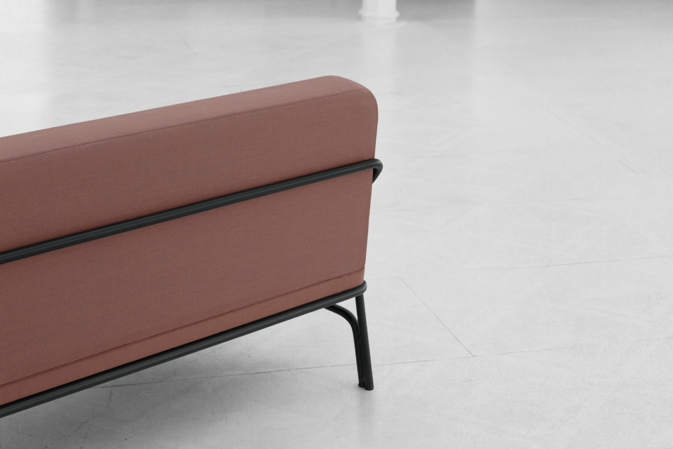 Minimalist sofa from the Nudo Collection by OGSB Studio, featuring a sleek design with a dark frame and warm fabric.