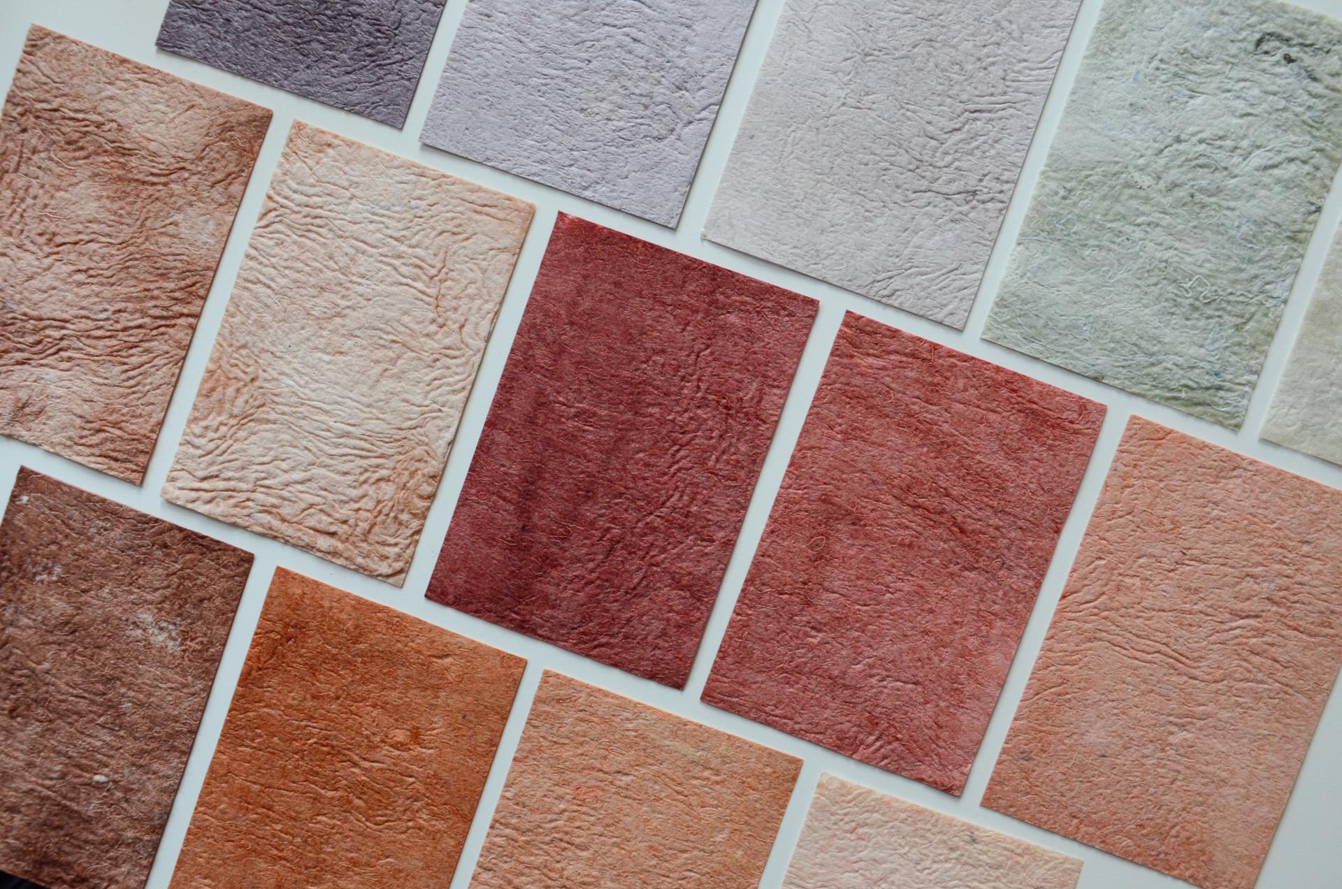 A collection of textured biomaterials in various earthy colors, showcasing innovative design through reimagined waste.