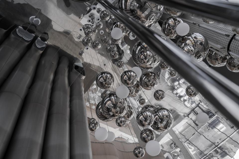 Contemporary interior design of MO bakehouse features reflective spheres and modern elements, creating a stylish espresso bar ambiance.