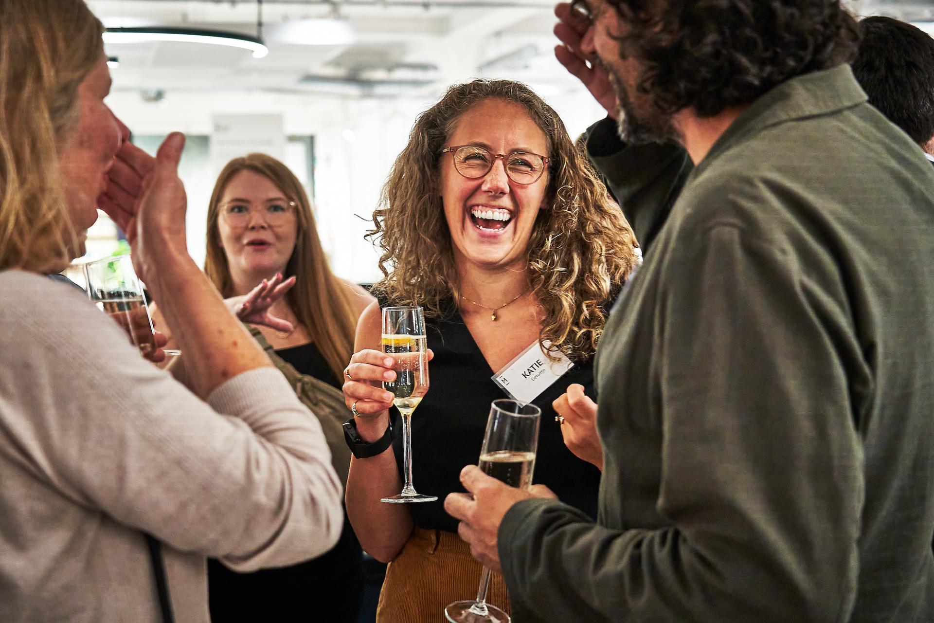 Celebration at the 42 Gathering event featuring podcast team members enjoying drinks and sharing laughter in a vibrant atmosphere.