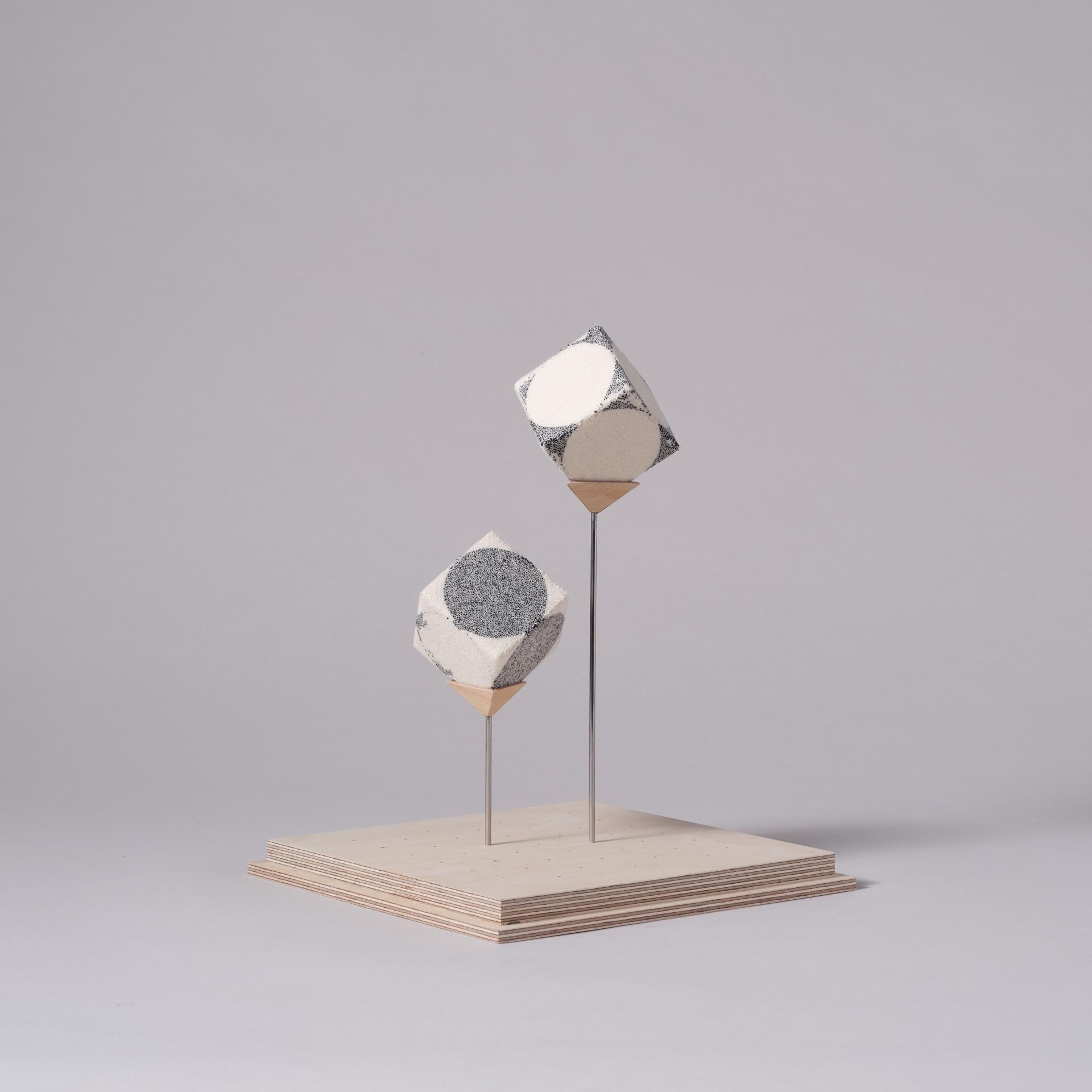 Contemporary geometric sculptures with contrasting textures displayed on a wooden base, highlighting innovative design techniques at London Craft Week 2024.