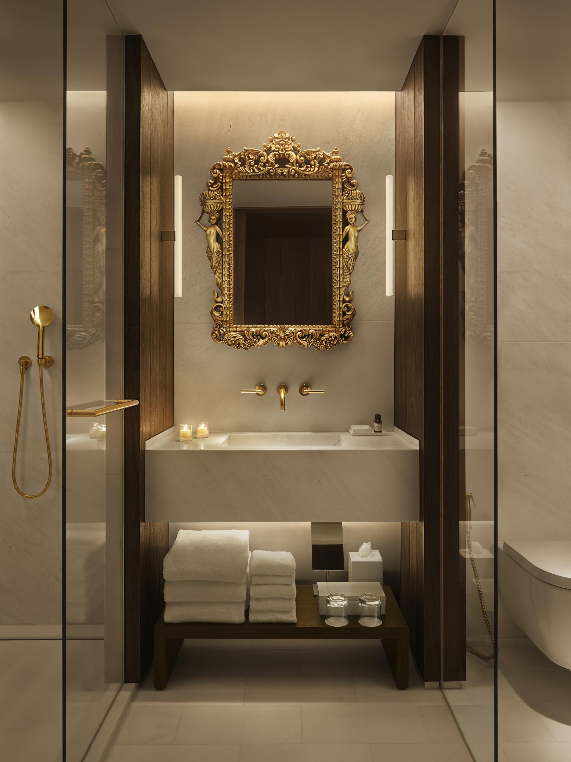 Luxurious bathroom interior at the Barcelona EDITION featuring ornate mirror, elegant fixtures, and plush towels.