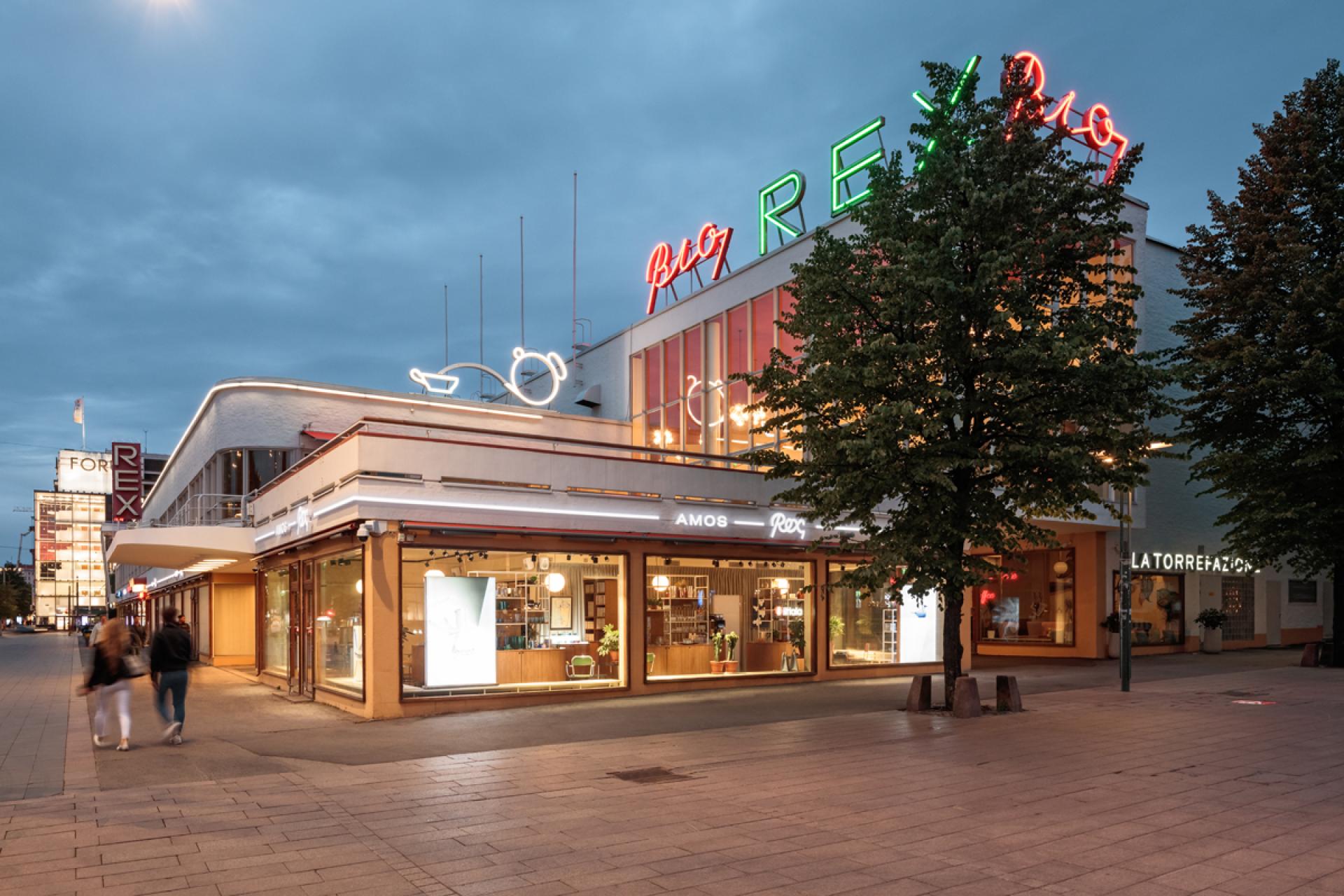 Vibrant exterior of Helsinki's new art museum featuring modern architecture and illuminated signage at twilight.