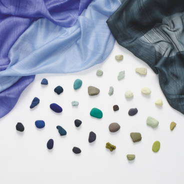 New Kvadrat textiles for Winter 2021 displayed alongside colorful stones, highlighting the innovative designs and textures.