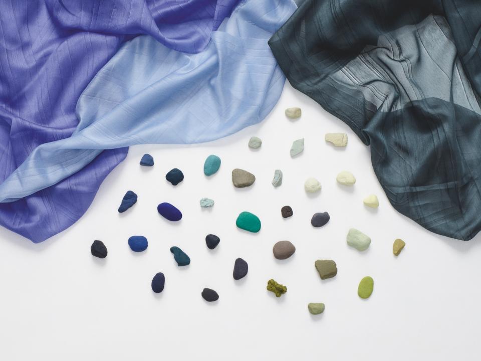 New Kvadrat textiles for Winter 2021 displayed alongside colorful stones, highlighting the innovative designs and textures.