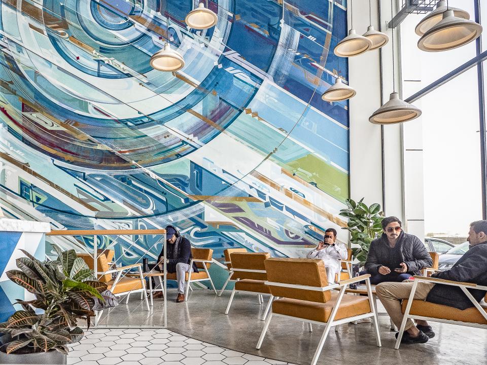 Modern interior of Brew92 cafe features stylish seating and vibrant wall art, creating a cozy atmosphere for coffee lovers.