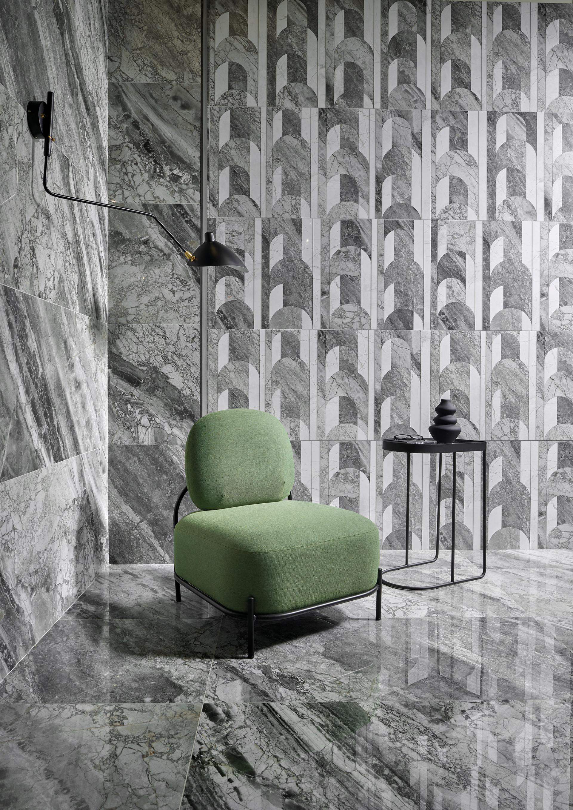 Stylish green lounge chair in a modern interior featuring textured ceramic tiles from Cevisama 2023.