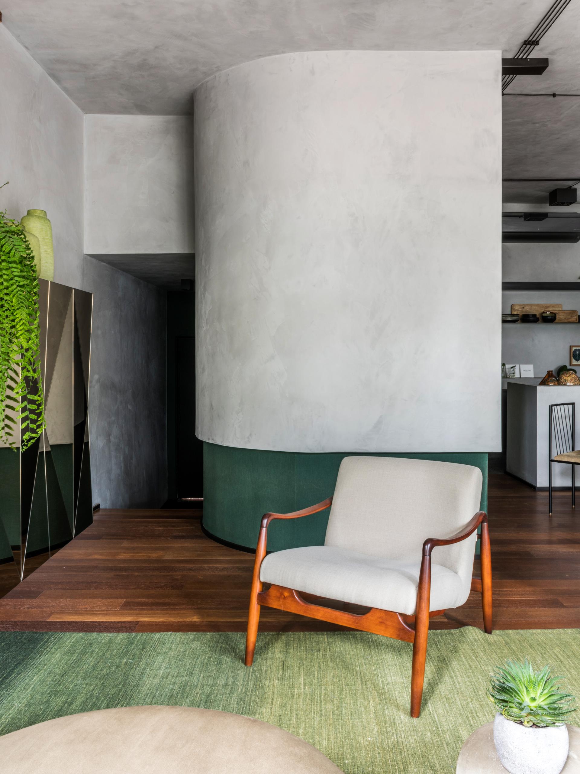 Modern interior design featuring a stylish armchair, greenery, and natural materials, highlighting a harmonious connection to nature.