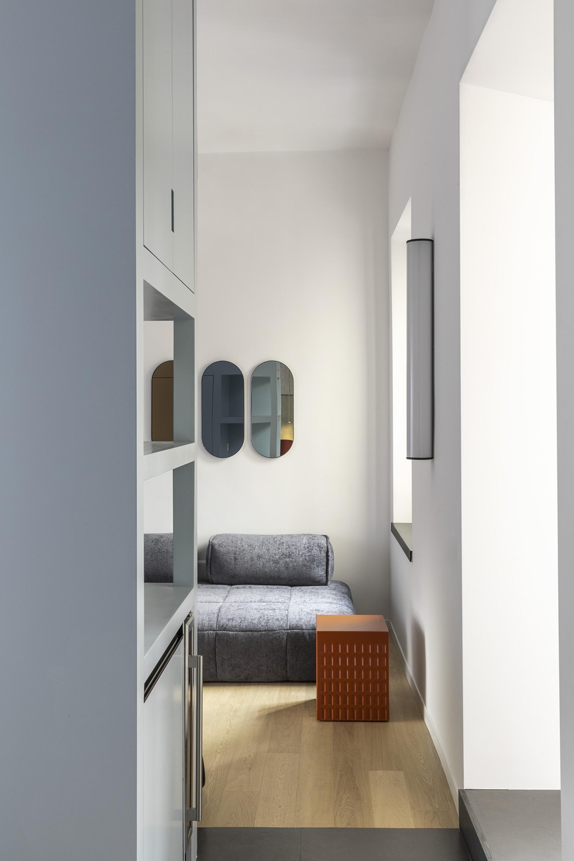 Stylish interior of a compact Trastevere apartment featuring a gray sofa and modern decorative elements.