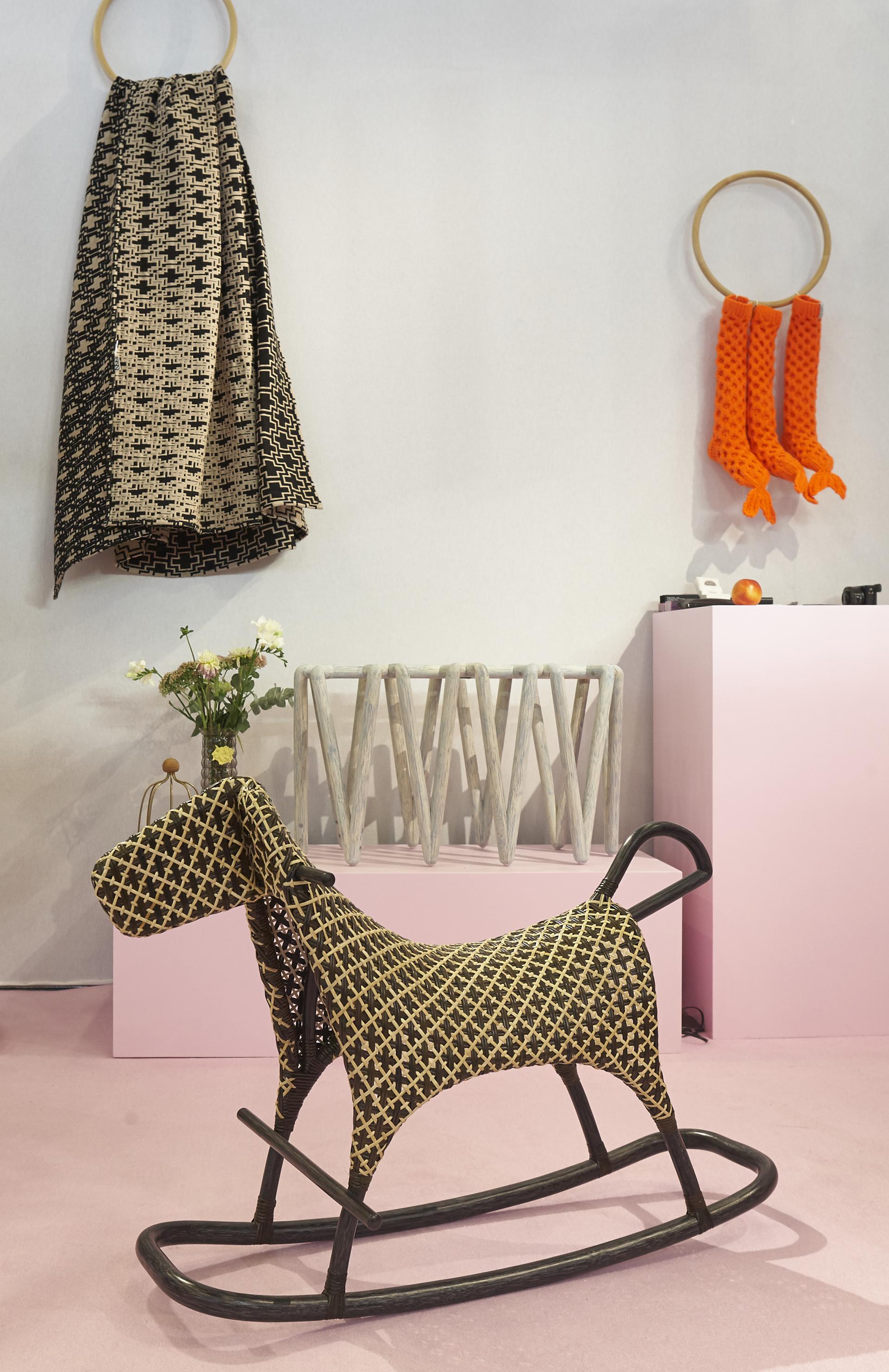 Stylish rocking horse toy surrounded by contemporary design elements at a Paris design exhibition.