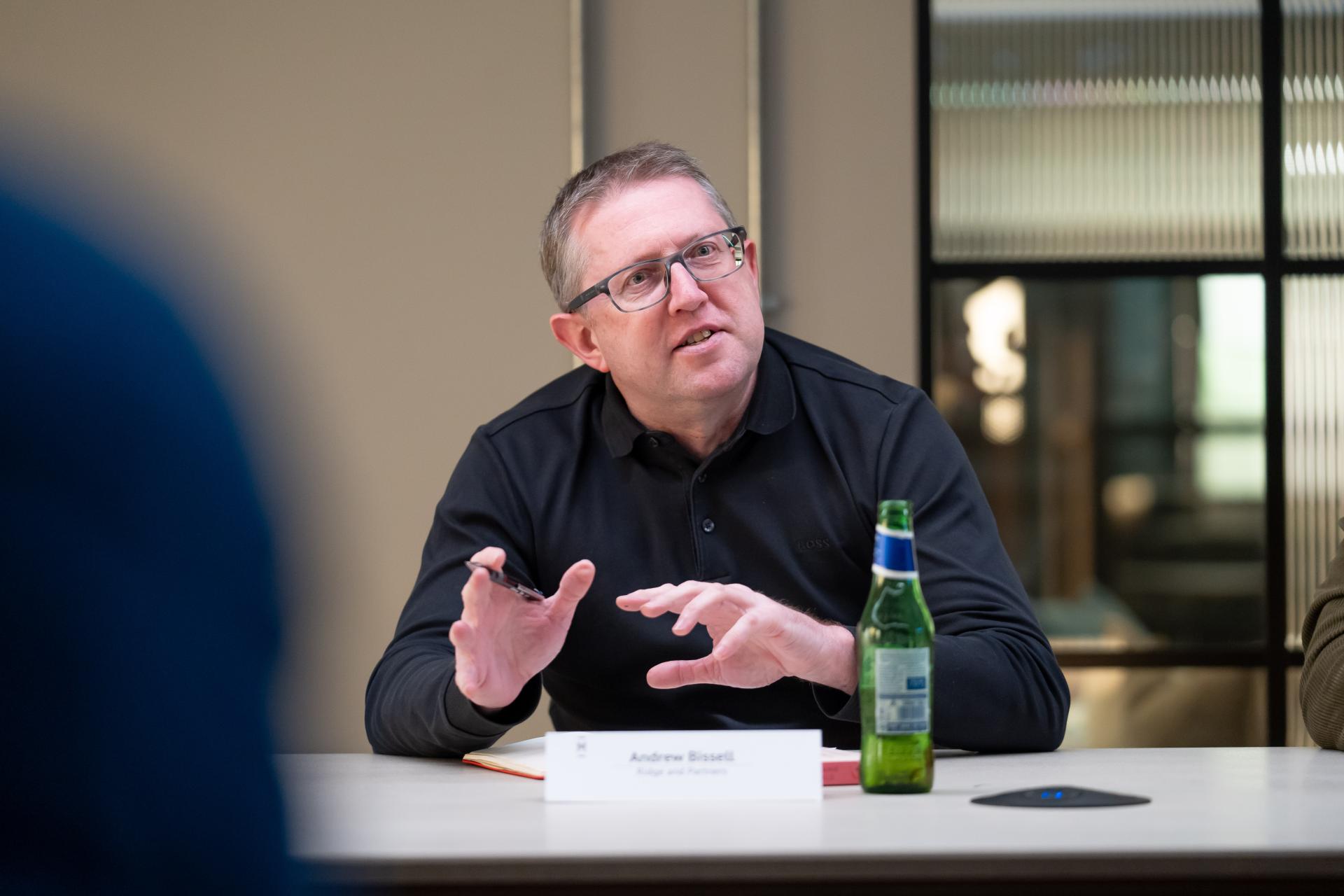 Andrew Bissell discusses EDI culture in a meeting setting, conveying important insights and engaging with participants.