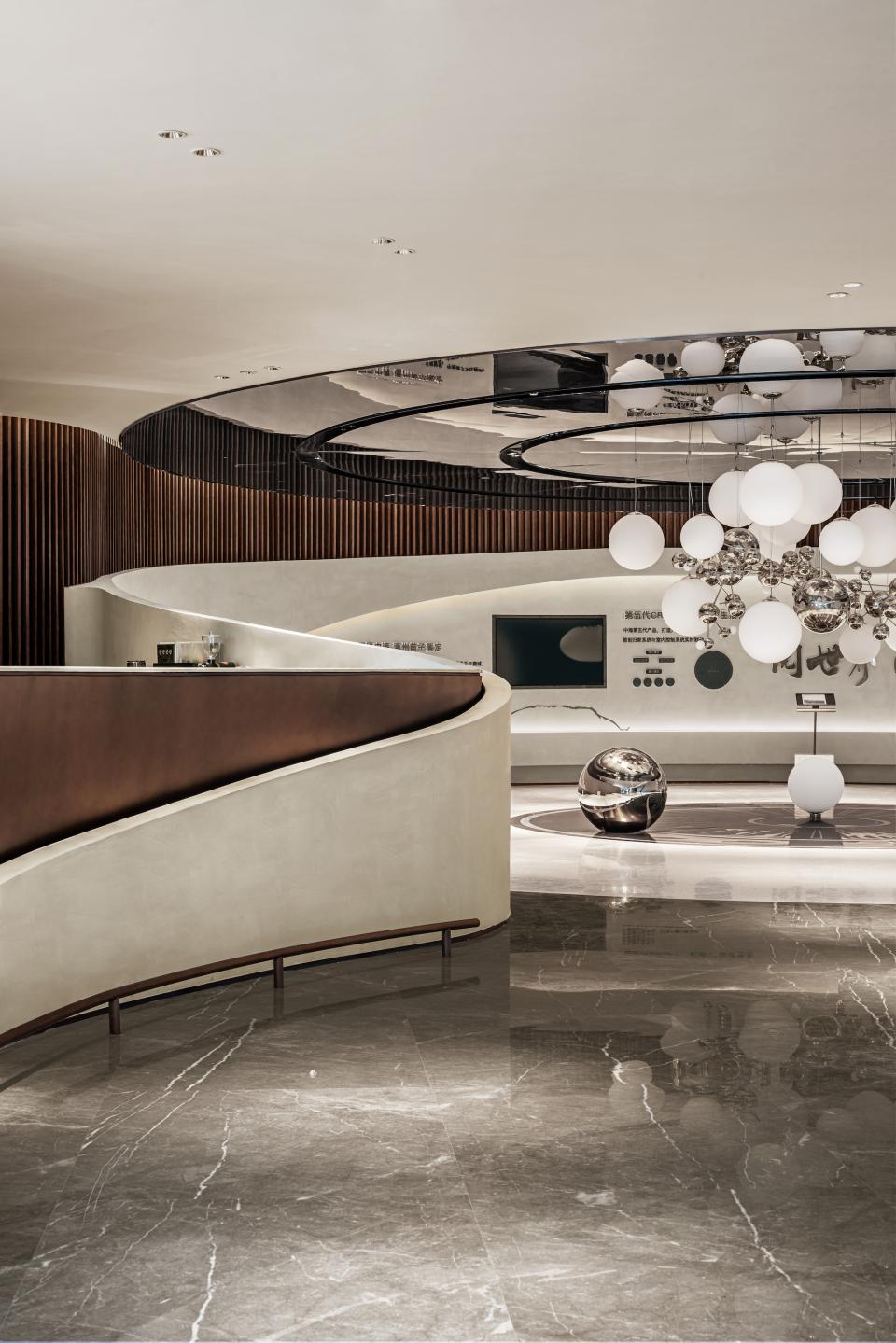 Elegant, modern lobby design featuring curved architecture, sleek marble flooring, and striking pendant lighting in Wenzhou City.