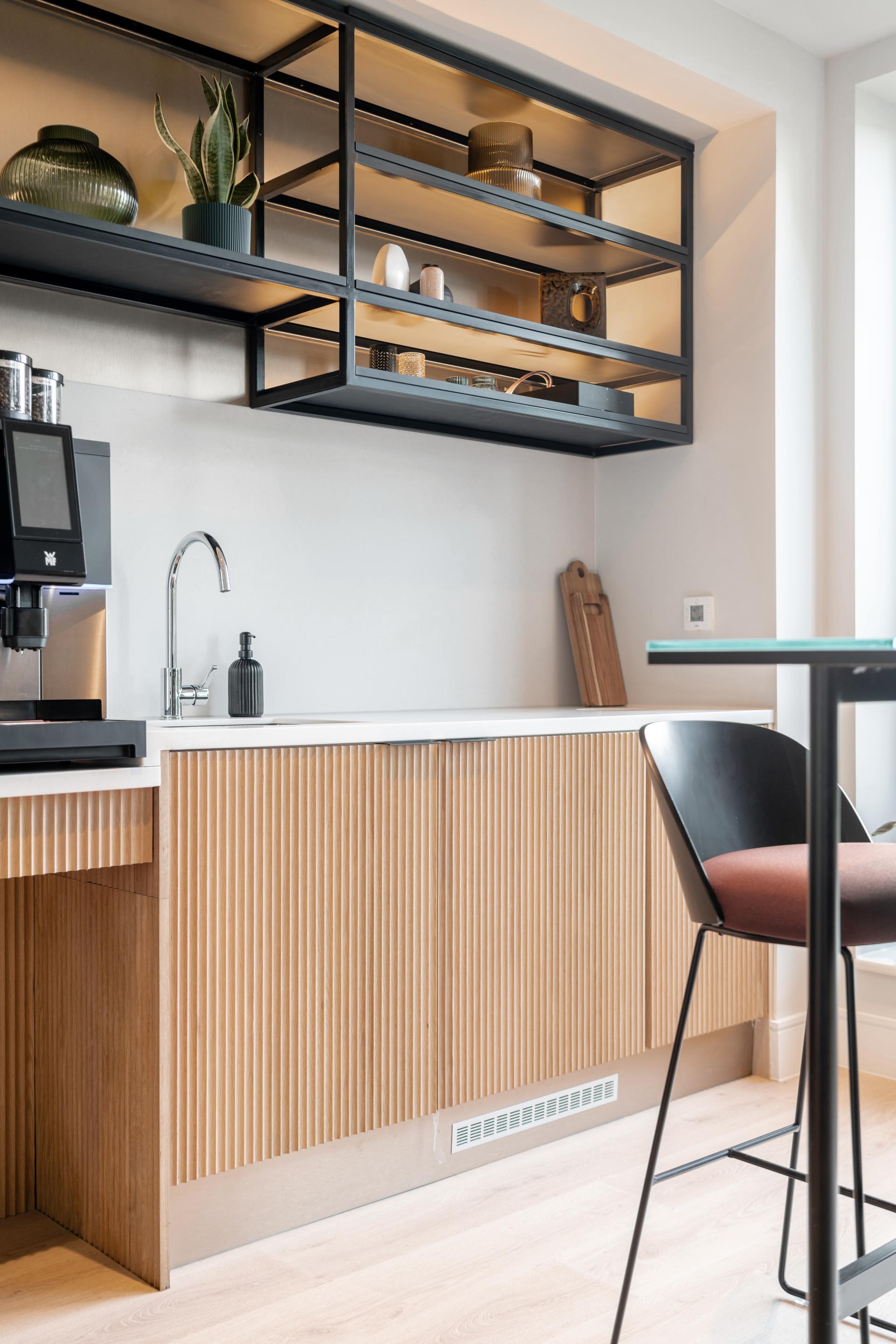 Modern kitchen space in co-living project The Apiary, featuring stylish cabinetry, coffee machine, and contemporary decor elements.