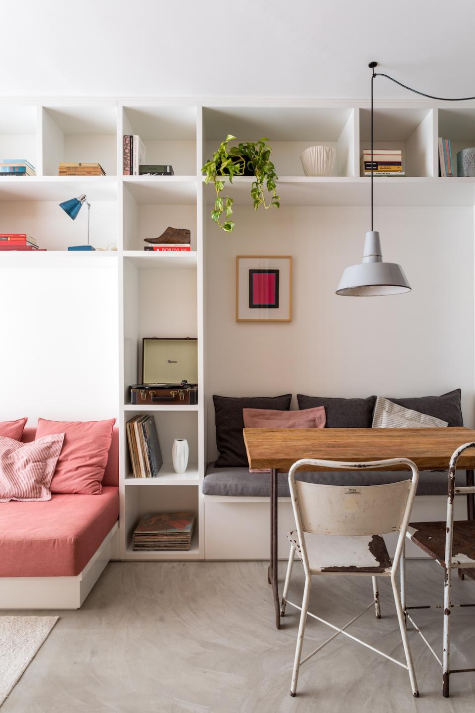 Cozy compact apartment interior designed by Leandro Garcia, featuring a stylish seating area and rustic dining table.