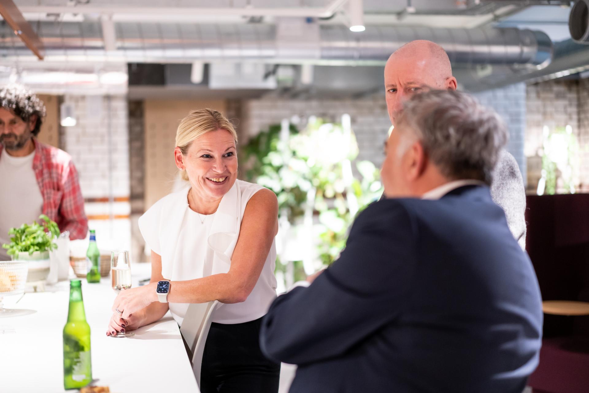 Professionals engaging in discussion at a modern gathering, reflecting on the evolving future of education post-pandemic.