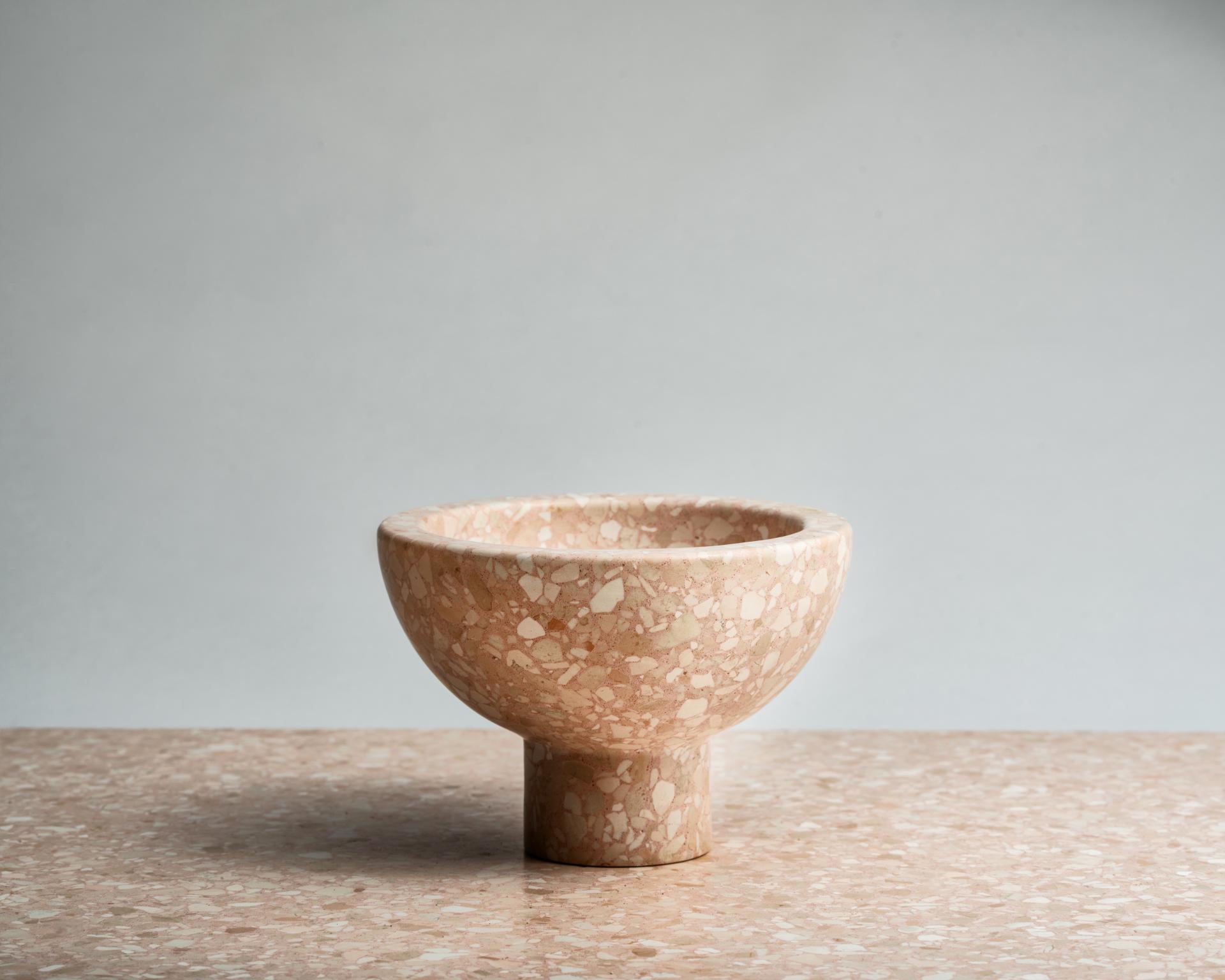 Terrazzo bowl from Joyce Wang's Flint collection, featuring a unique pink pattern, displayed on a matching surface.