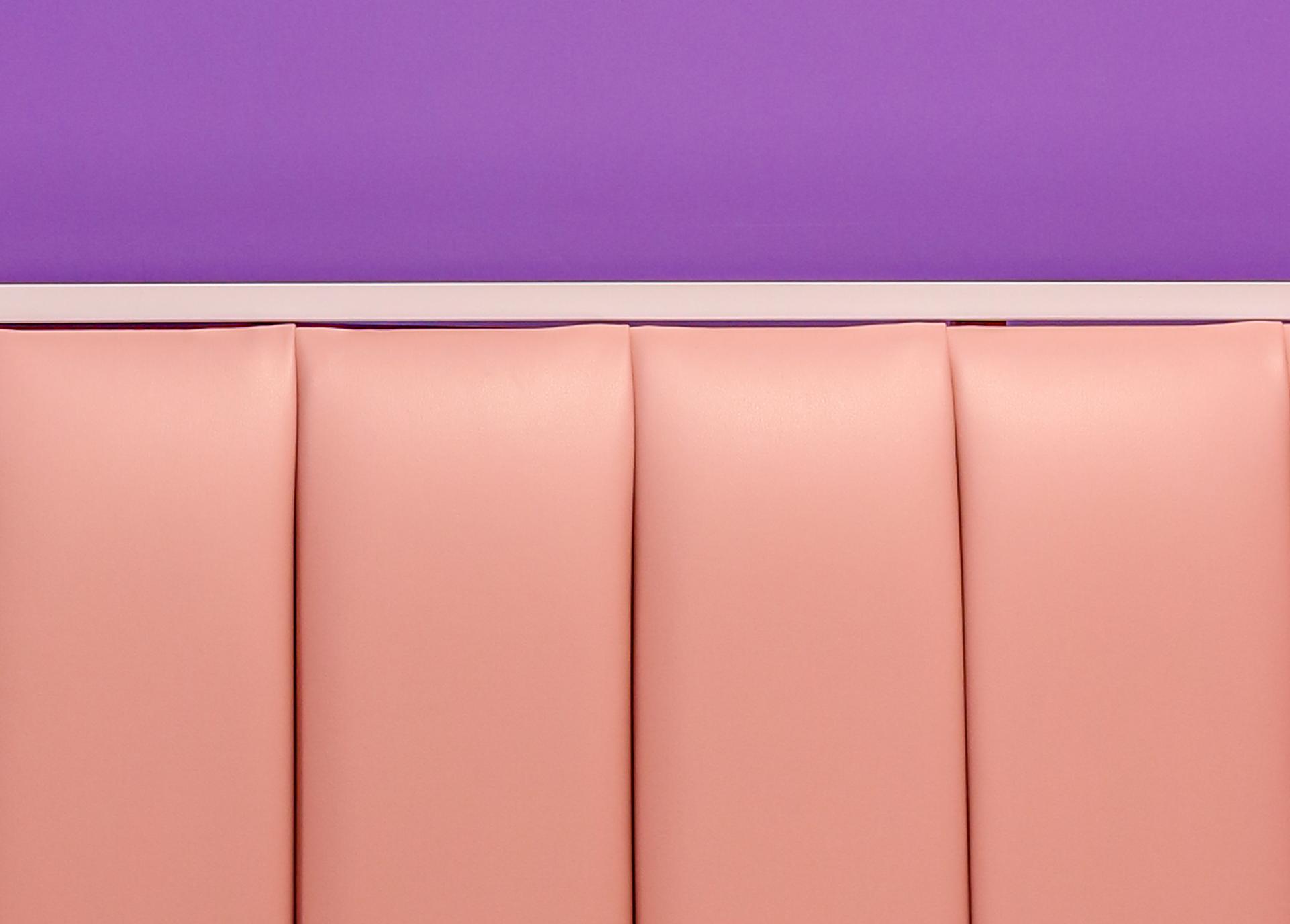 Vibrant pink seating with a purple wall backdrop, showcasing Phoenix Wharf's colorful design at Oh So Yum! in Bradford.