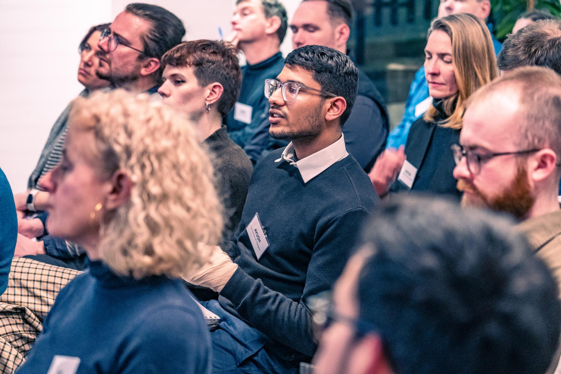 Audience engaged in a seminar discussion about net zero carbon buildings, showcasing diverse participants and a collaborative atmosphere.