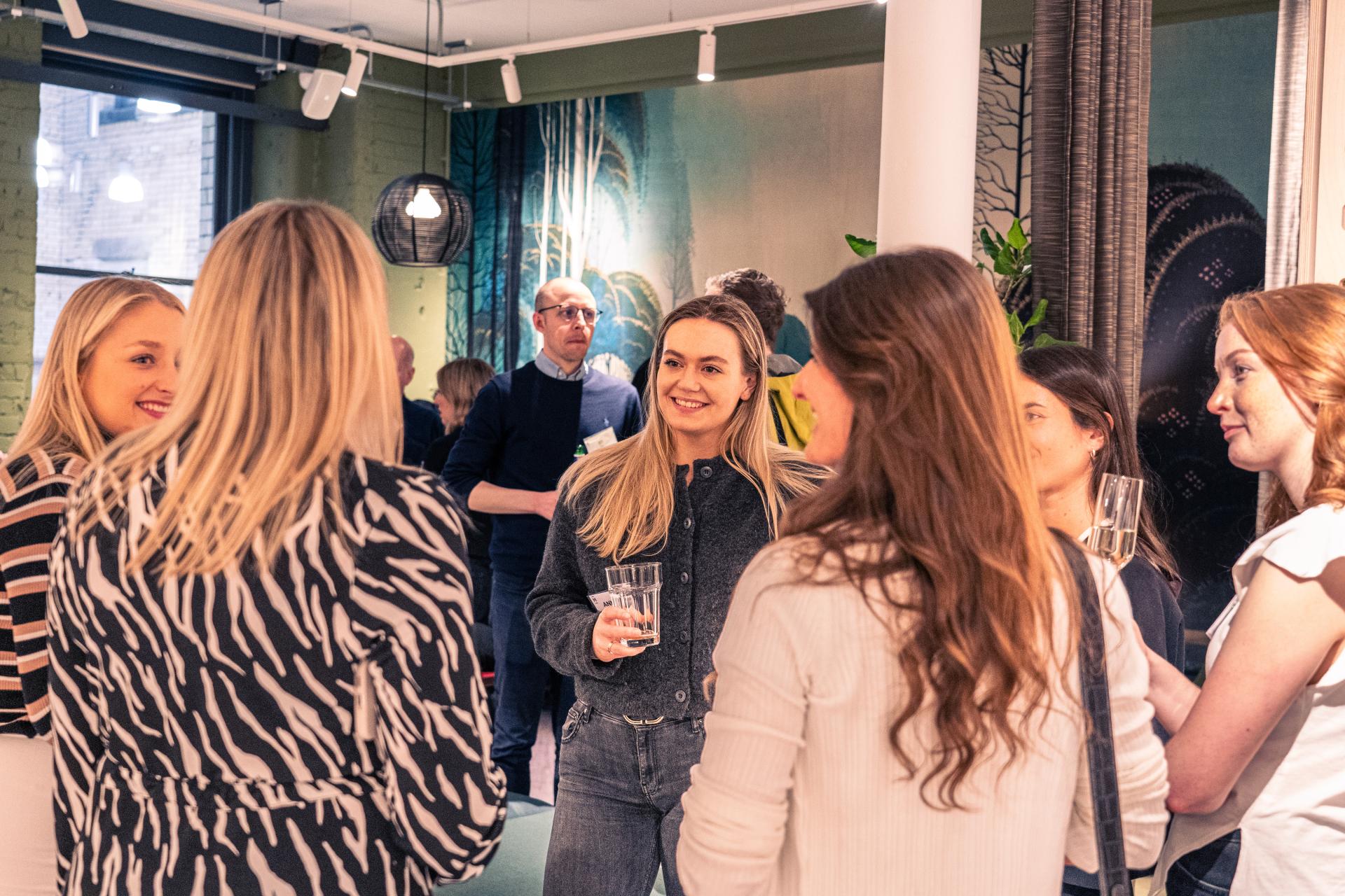 Attendees engaging in conversation at a design event featuring Dr. Stephanie Fitzgerald, highlighting EDI in creative fields.