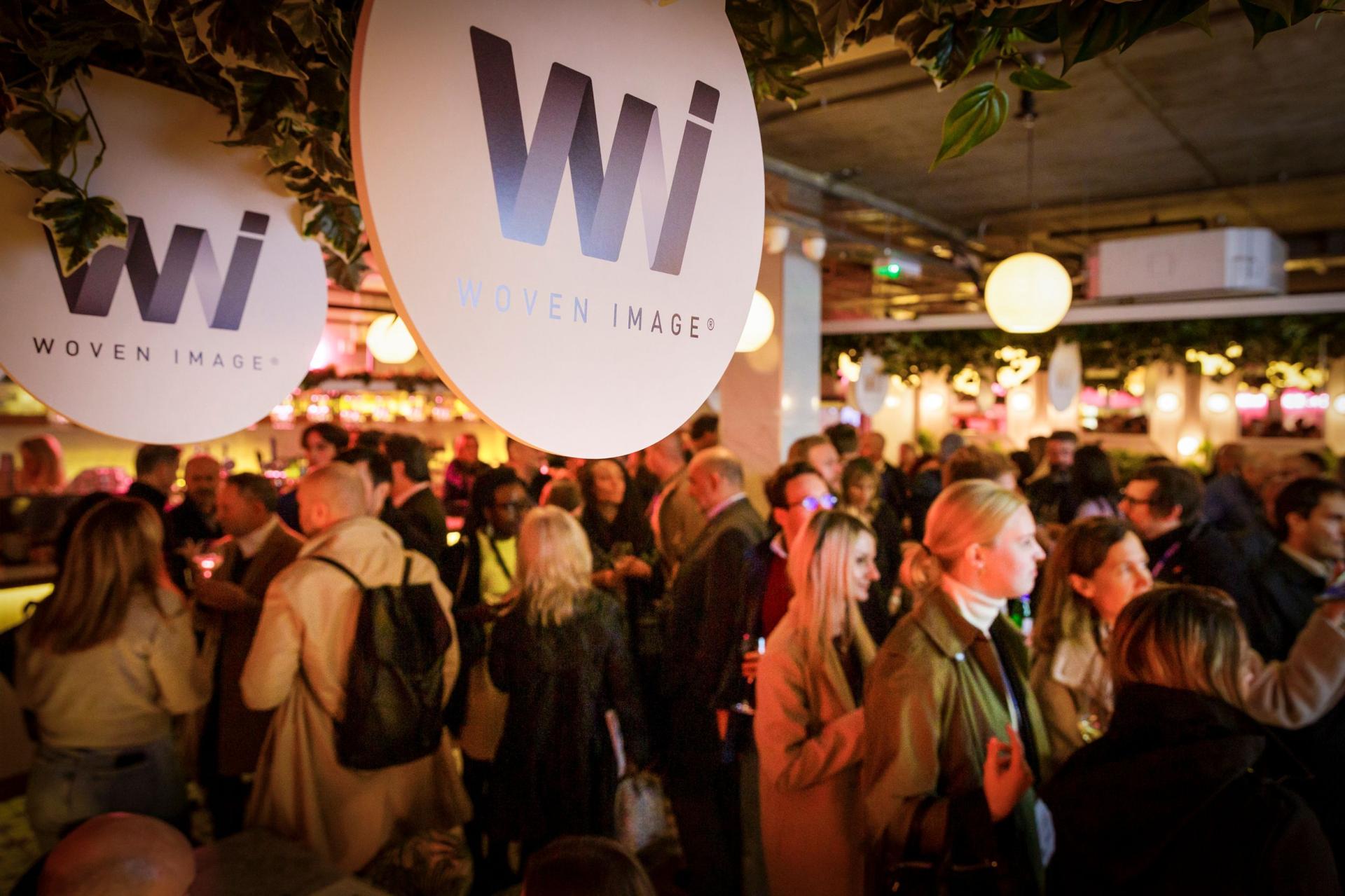 Lively networking event at the 2023 Workspace Design Show celebrating the theme 'Destination Workplace' with attendees engaged in conversation.