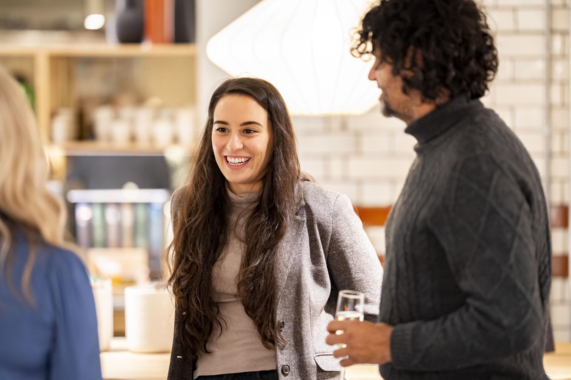 Participants engaging in conversation at a workplace gathering, highlighting the impact of data on collaboration and technology.